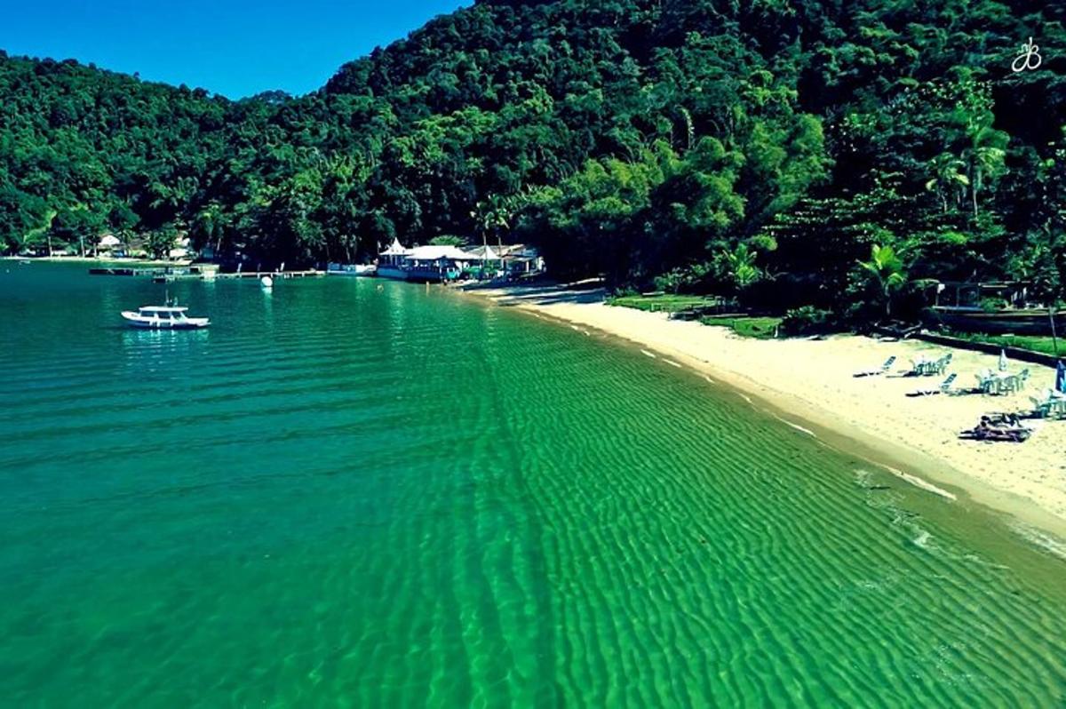 Una playa con sillas y un bote en el agua.
