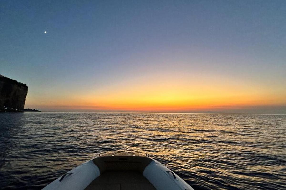 una barca in acqua con un tramonto