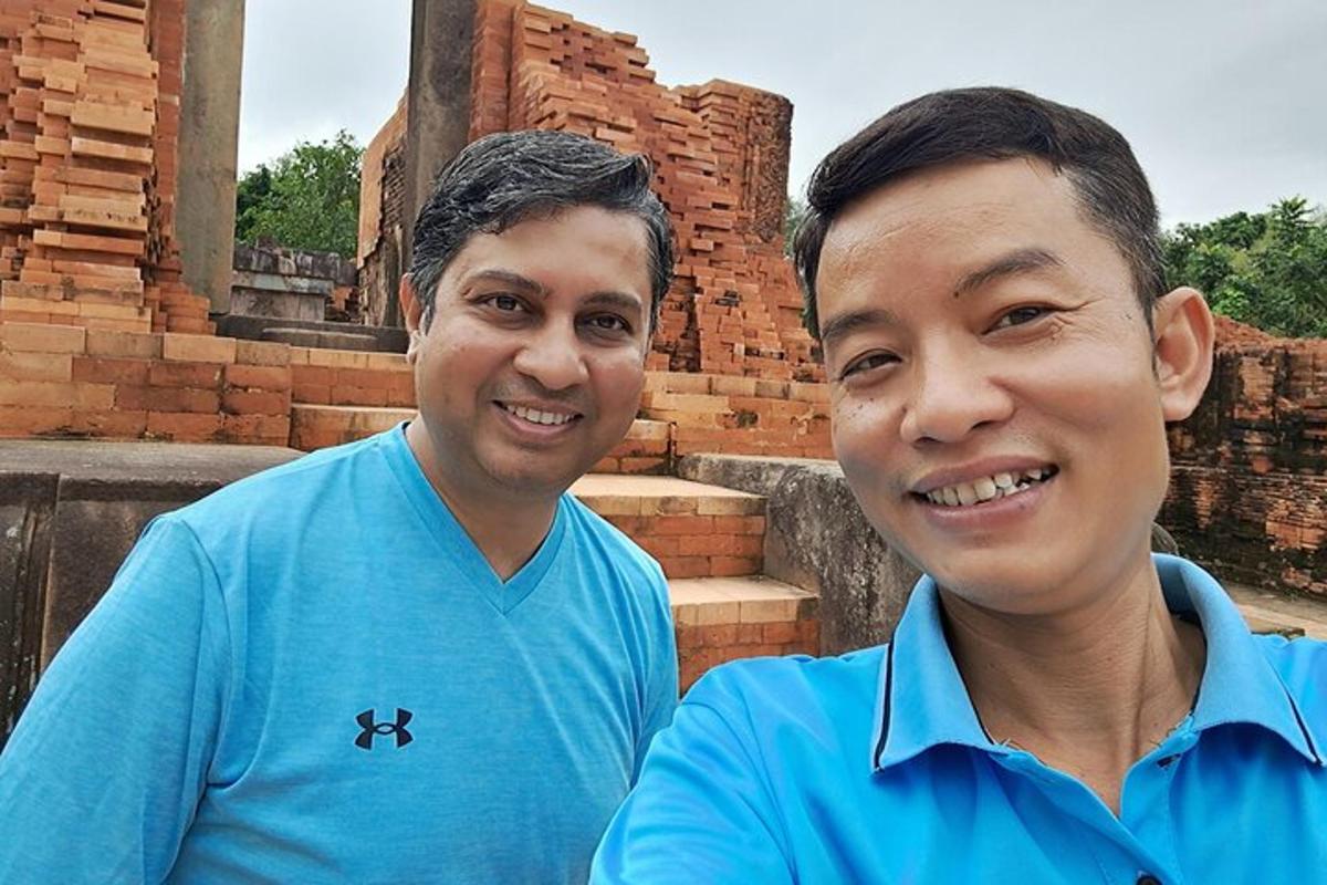 two men in blue shirts posing for a picture