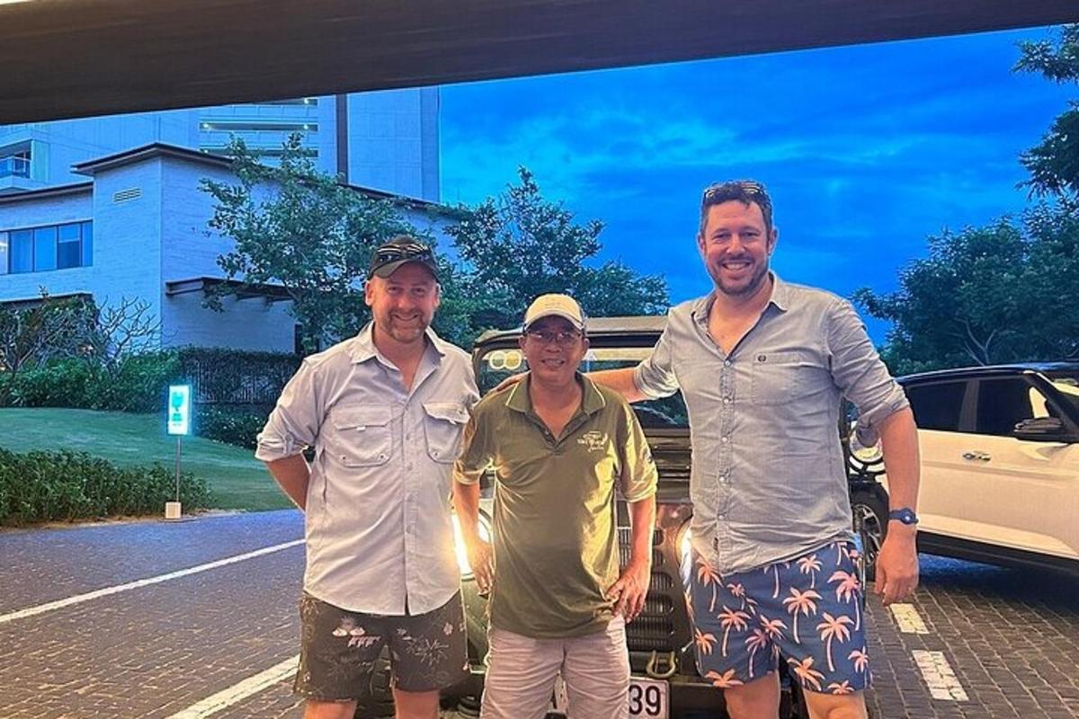 tre uomini sono in piedi davanti a un'auto