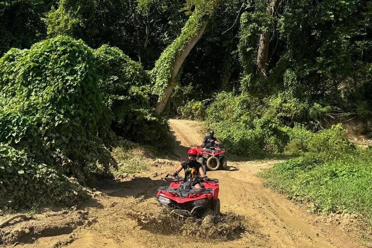 Δύο άτομα οδηγούν σε ATV σε χωματόδρομο