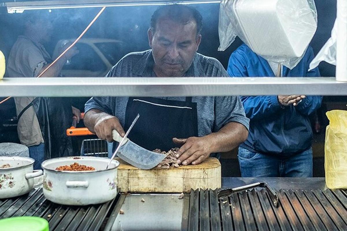 ένας άντρας μαγειρεύει φαγητό σε κατσαρόλα στη σχάρα