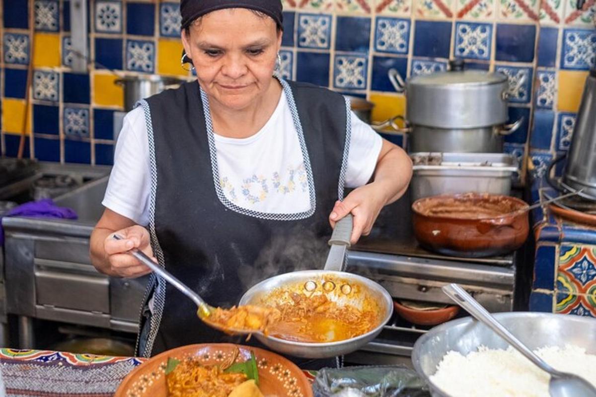 egy nő ételt főz egy serpenyőben a konyhában