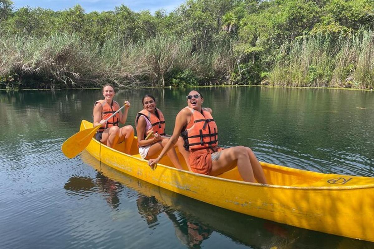 tre persone in una canoa gialla su un fiume