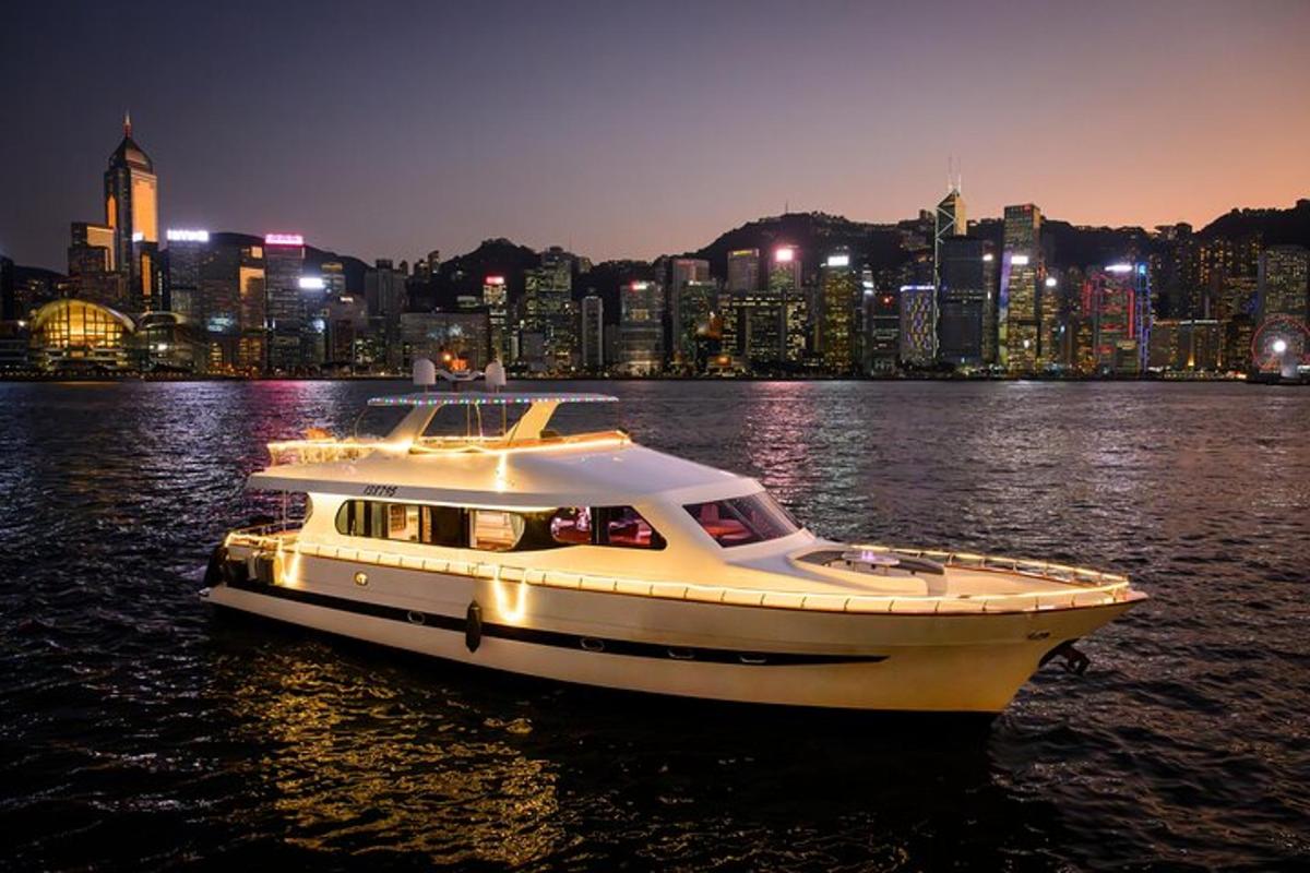 a white boat in the water with a city at night