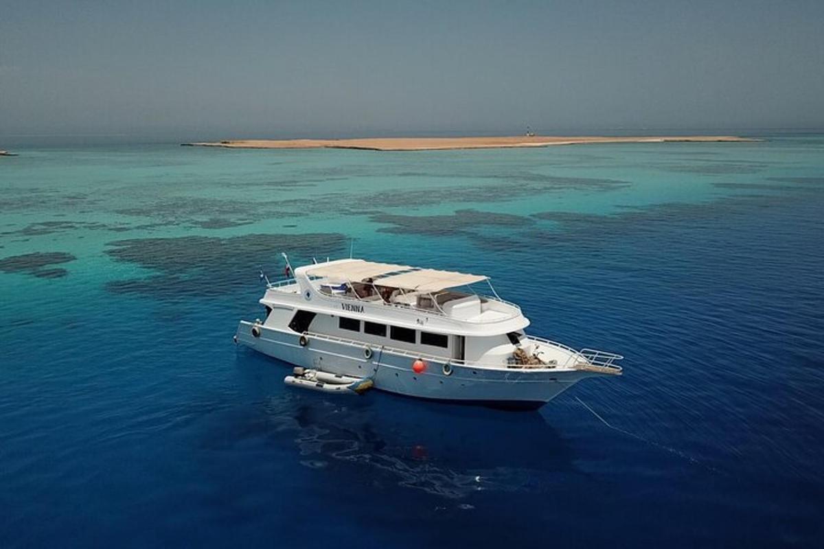 una barca bianca che galleggia nell'acqua vicino a un'isola