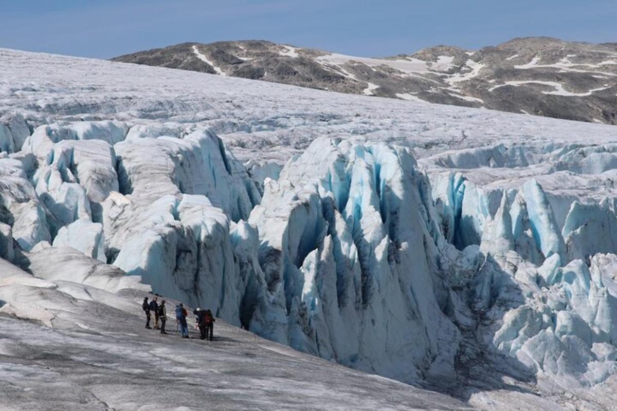 a group of people standing in front of a glacier