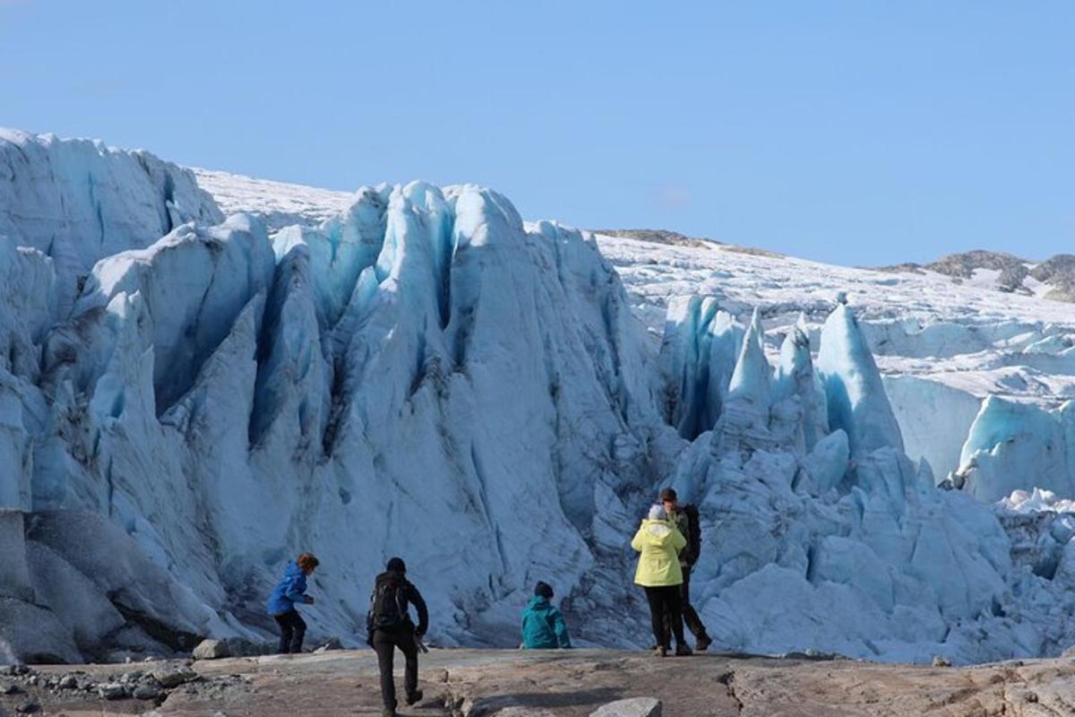 a group of people standing in front of a glacier