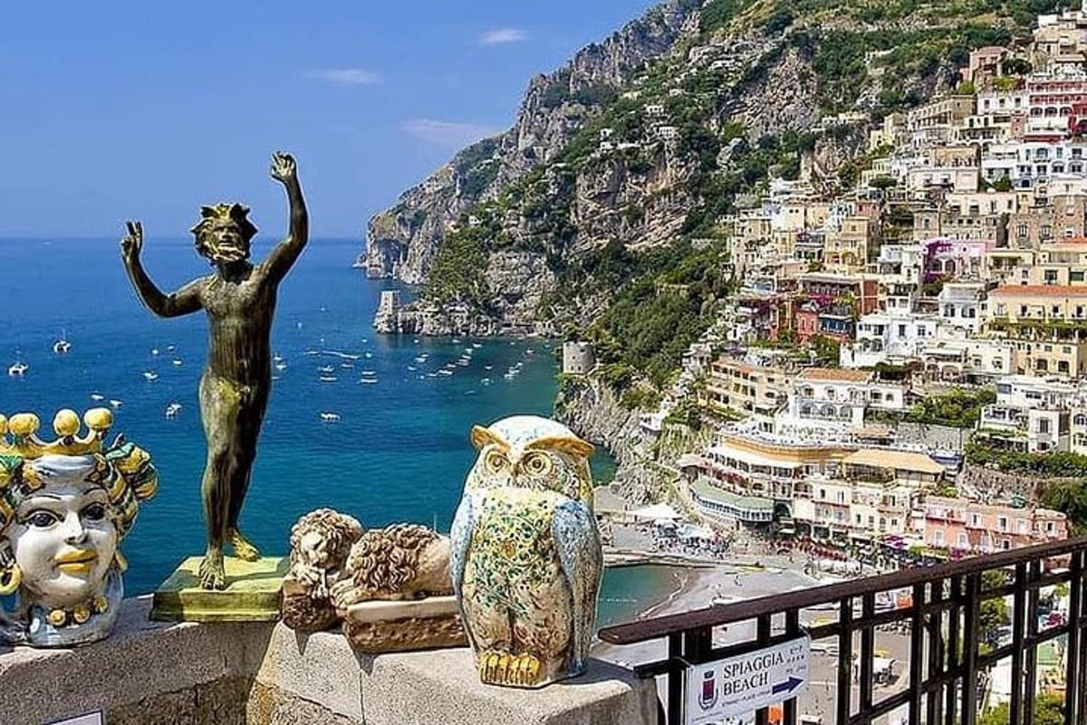 a statue of a man standing on a ledge overlooking a city