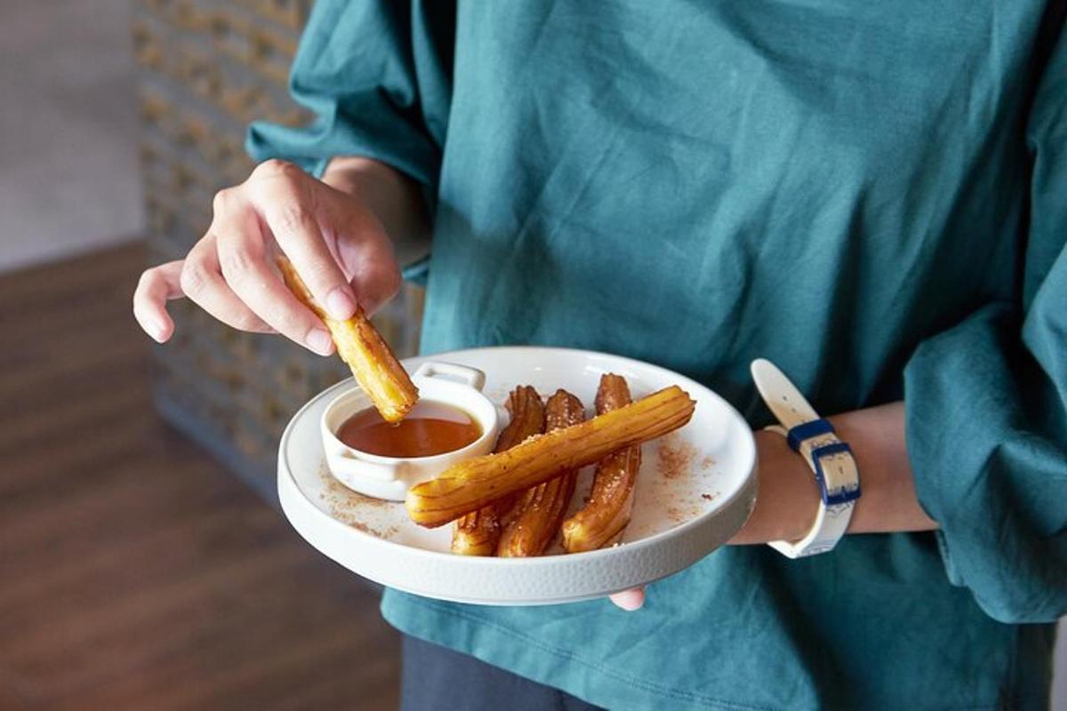 una persona che tiene in mano un piatto di patatine fritte e salsa