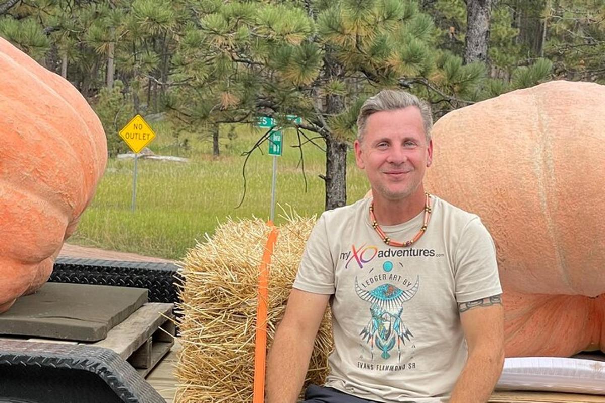a man sitting next to a pile of hay