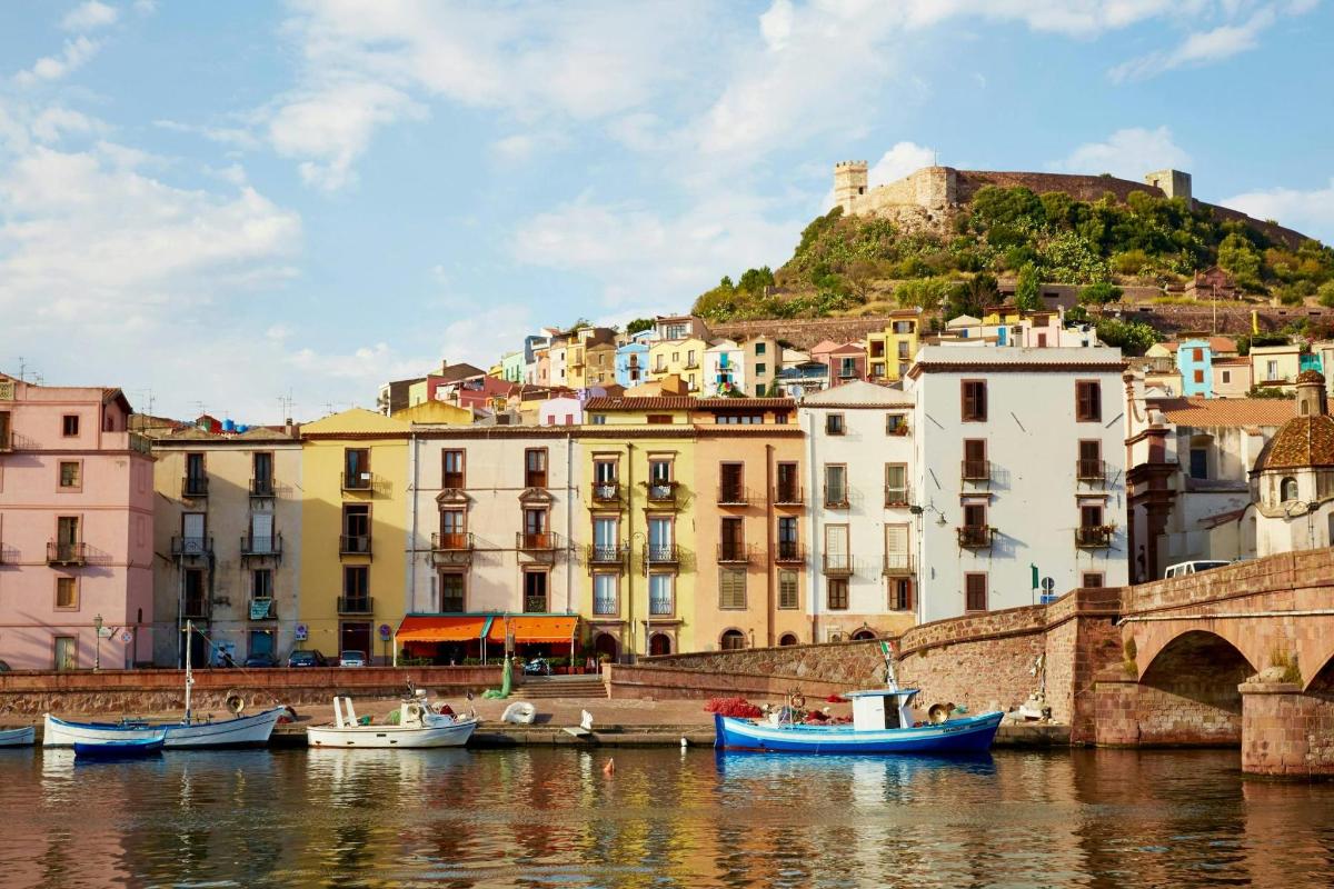 a group of boats in a body of water with buildings