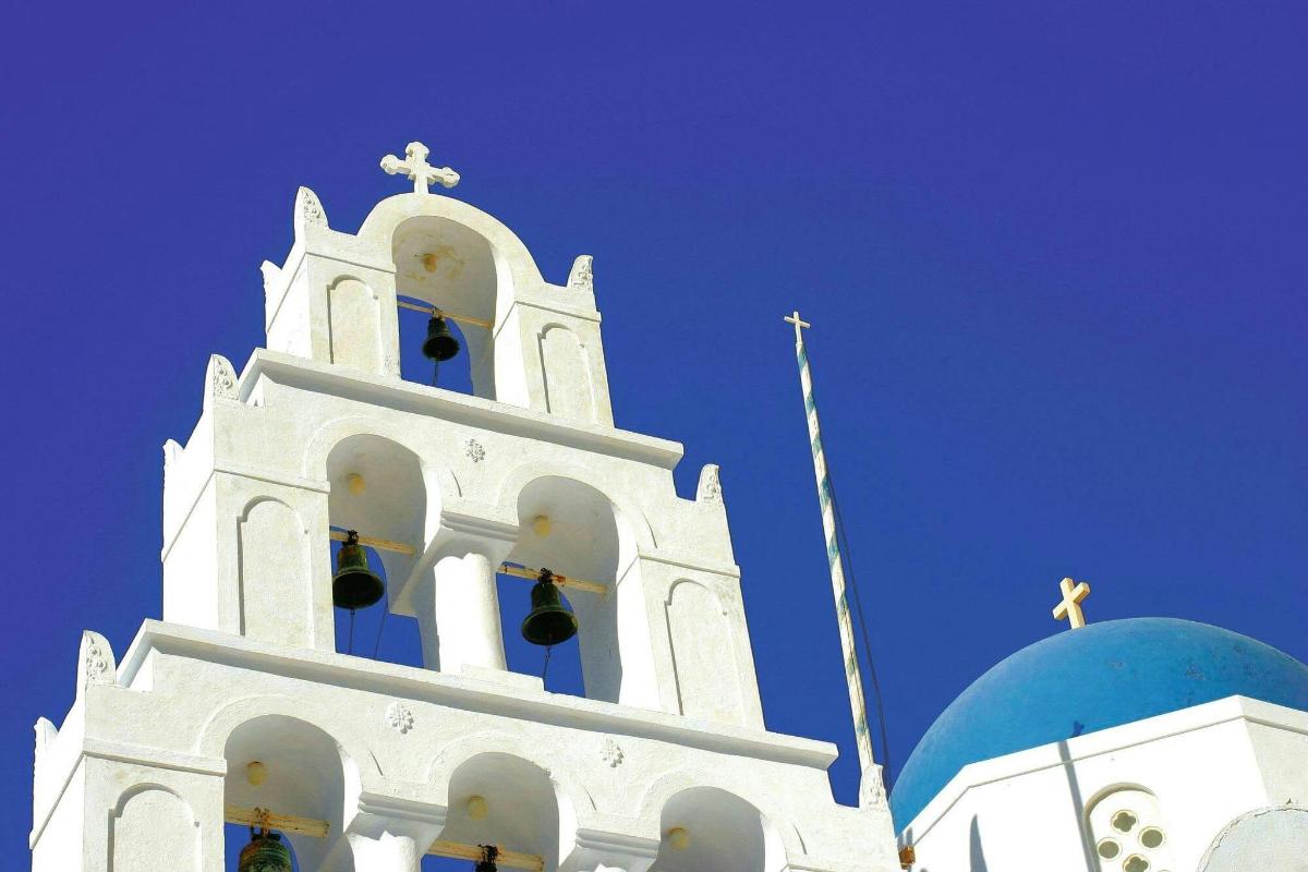 Un campanario de iglesia blanco con una cruz en la parte superior