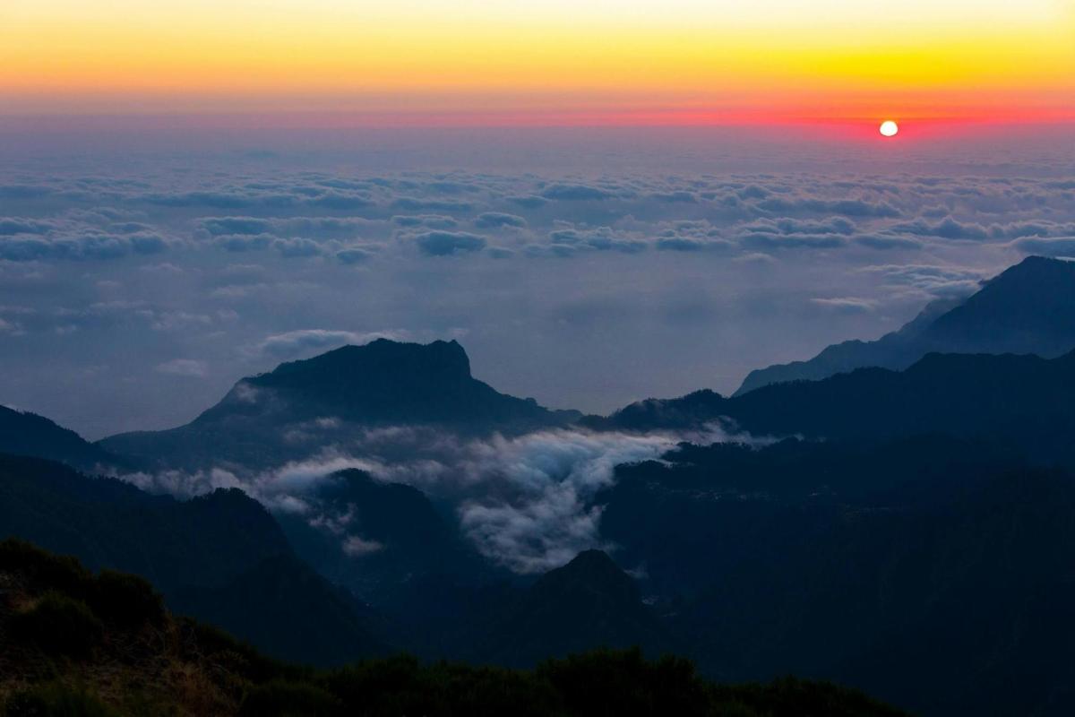 a view of the sun setting over a mountain range