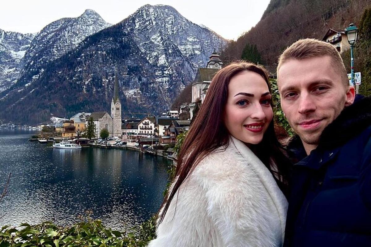 un uomo e una donna in piedi accanto a uno specchio d'acqua