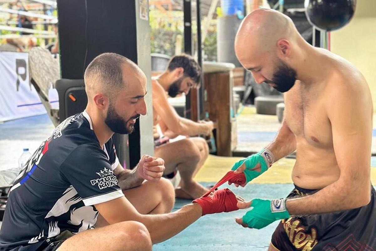 dua lelaki dengan sarung tangan tinju di tangan mereka di gimnasium