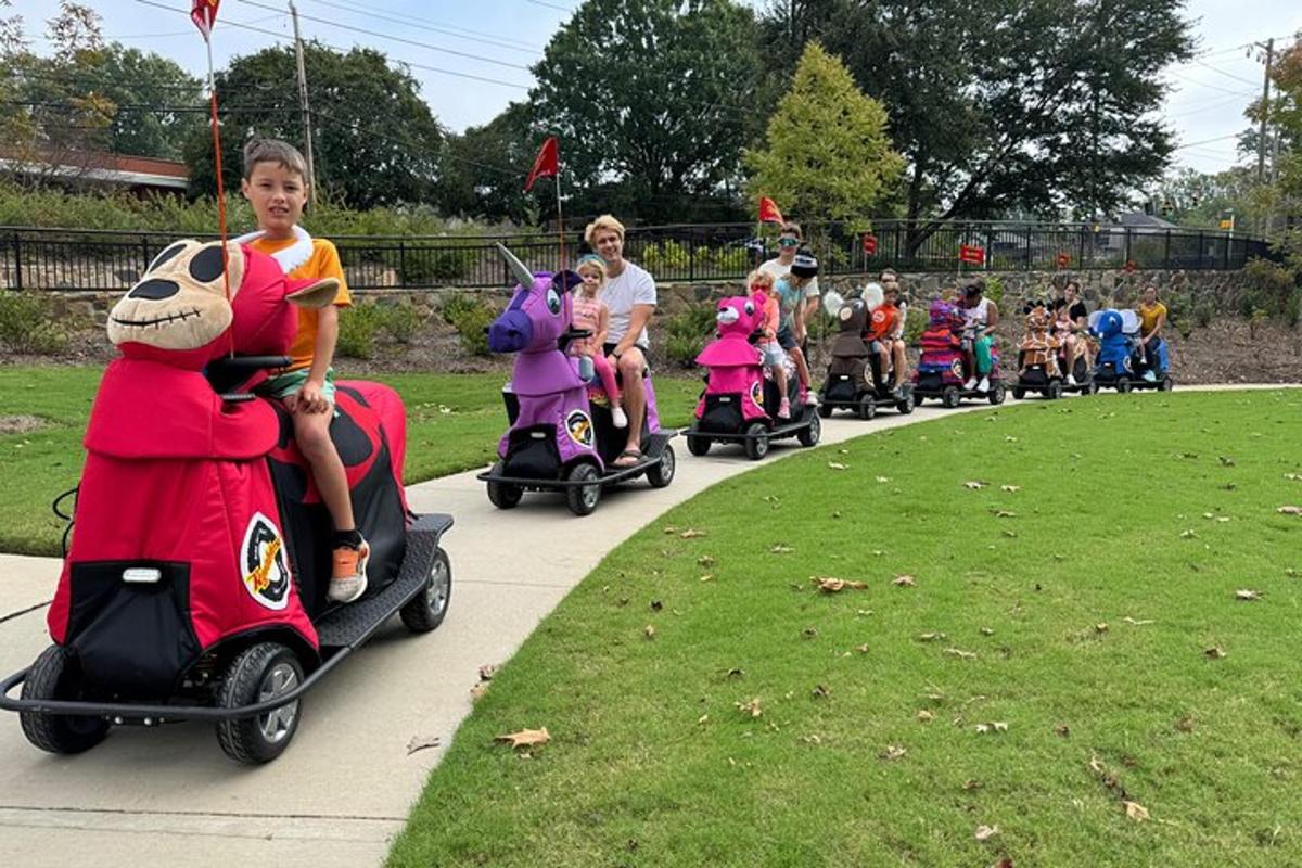 a group of children riding on scooters on a road