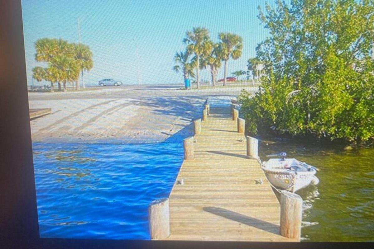 a wooden dock with a boat on the water