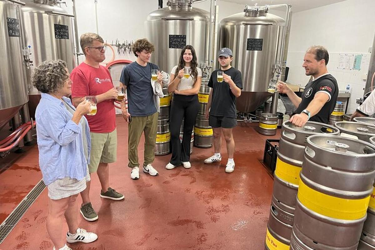 Un grupo de personas de pie en una cervecería con barriles de vino.