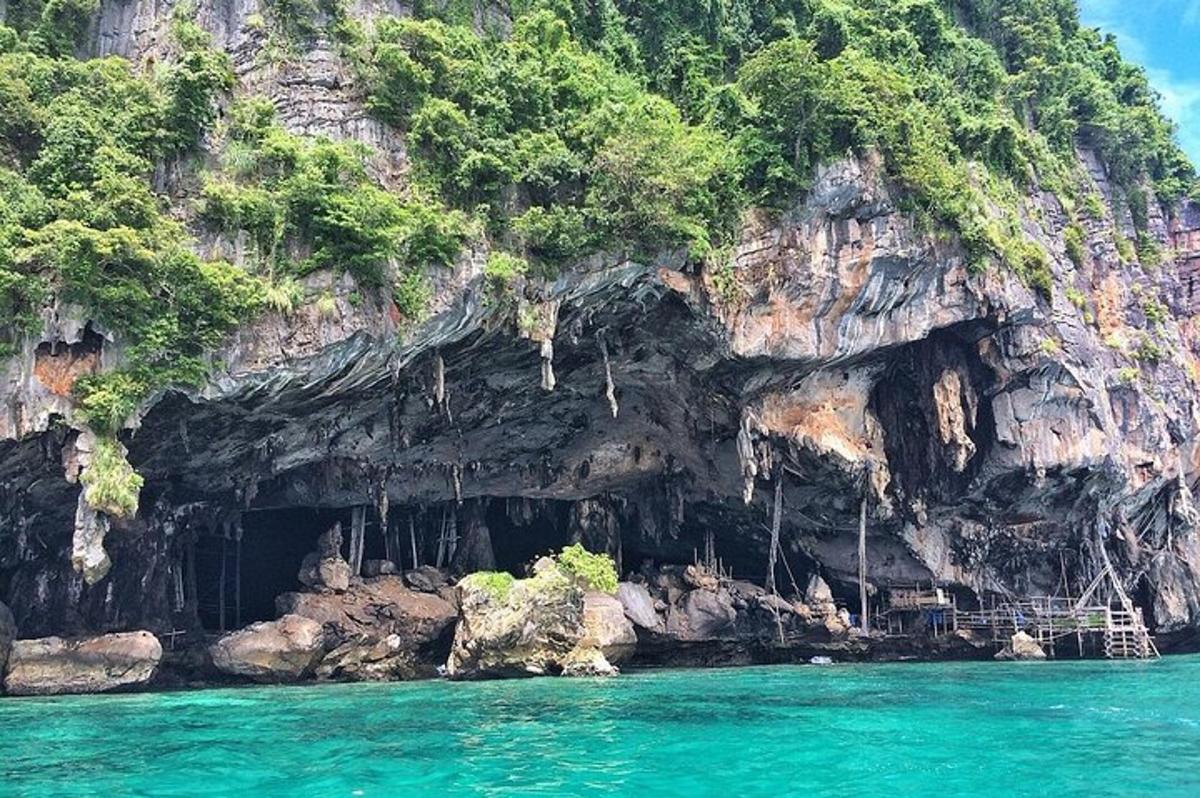 a cave in the side of a mountain with blue water
