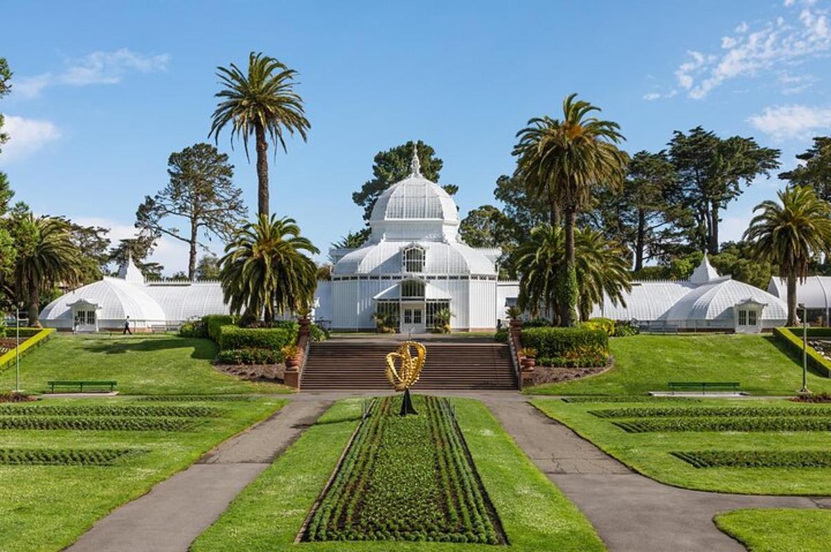 Un gran edificio blanco con palmeras al fondo.