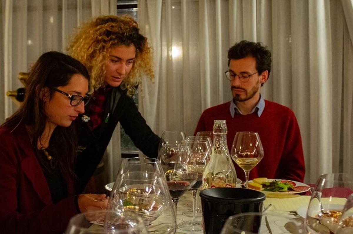 un gruppo di persone sedute a un tavolo con bicchieri di vino