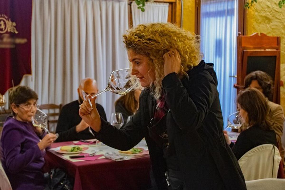 o femeie stând la o masă, bând vin