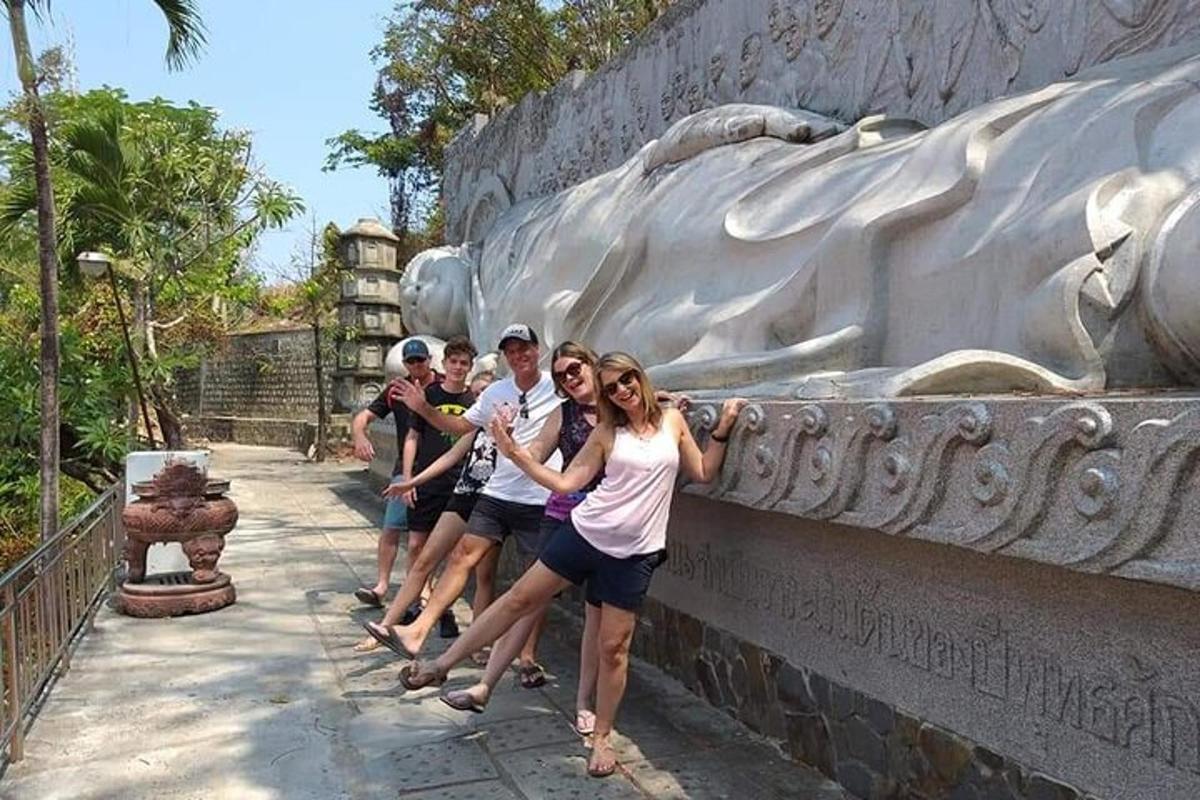 un gruppo di persone in piedi accanto a una statua