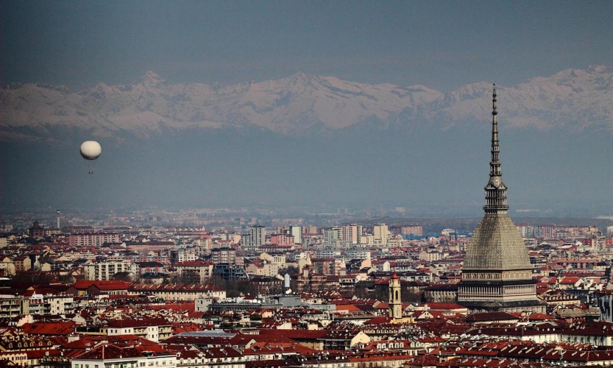 una vista di una città con una torre e montagne