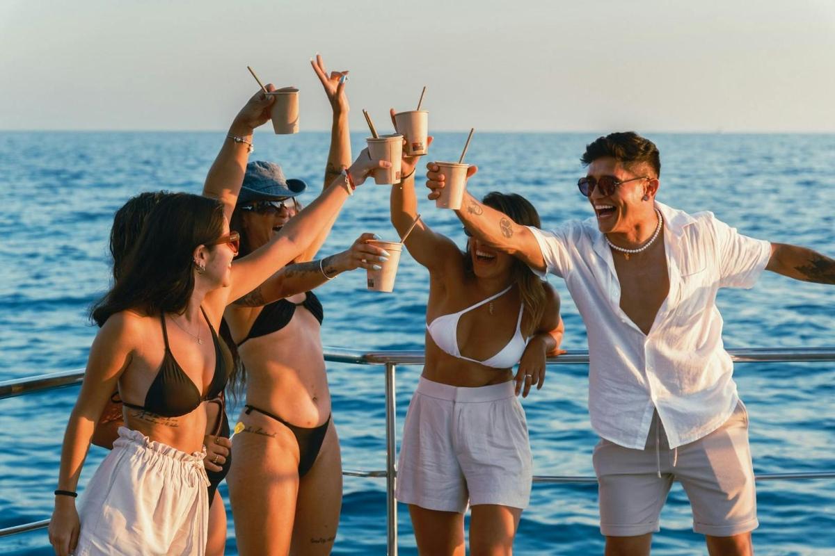 eine Gruppe von Menschen steht mit Getränken auf einem Boot
