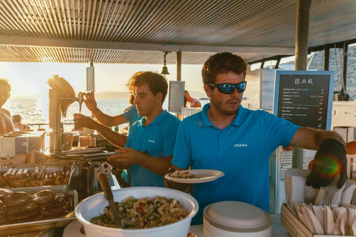 zwei Männer stehen an einem Buffet und bereiten Essen vor