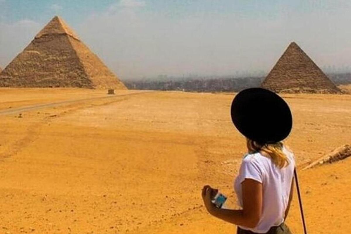 a woman standing in front of the pyramids