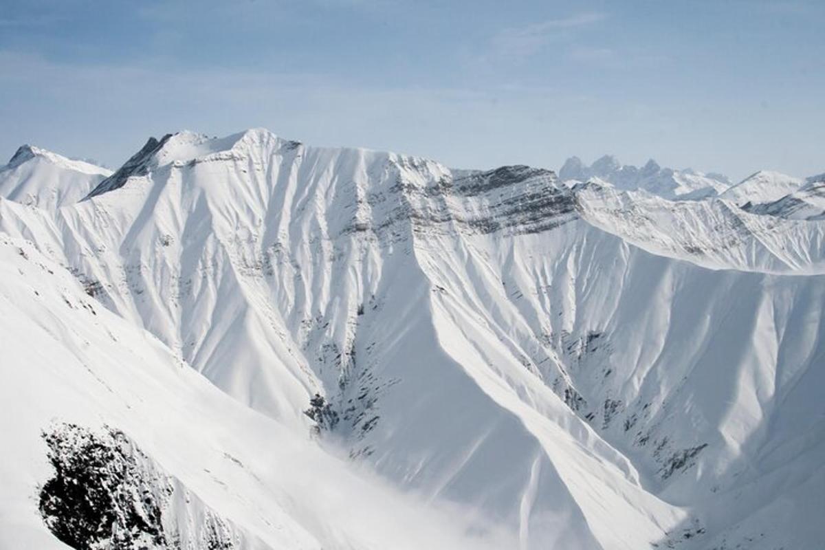 una catena montuosa coperta di neve con neve sopra