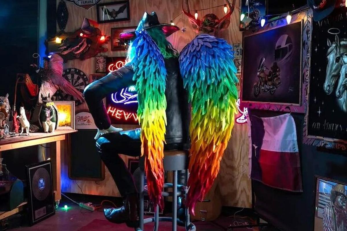 seseorang yang duduk di bar dengan burung kakak tua yang berwarna-warni