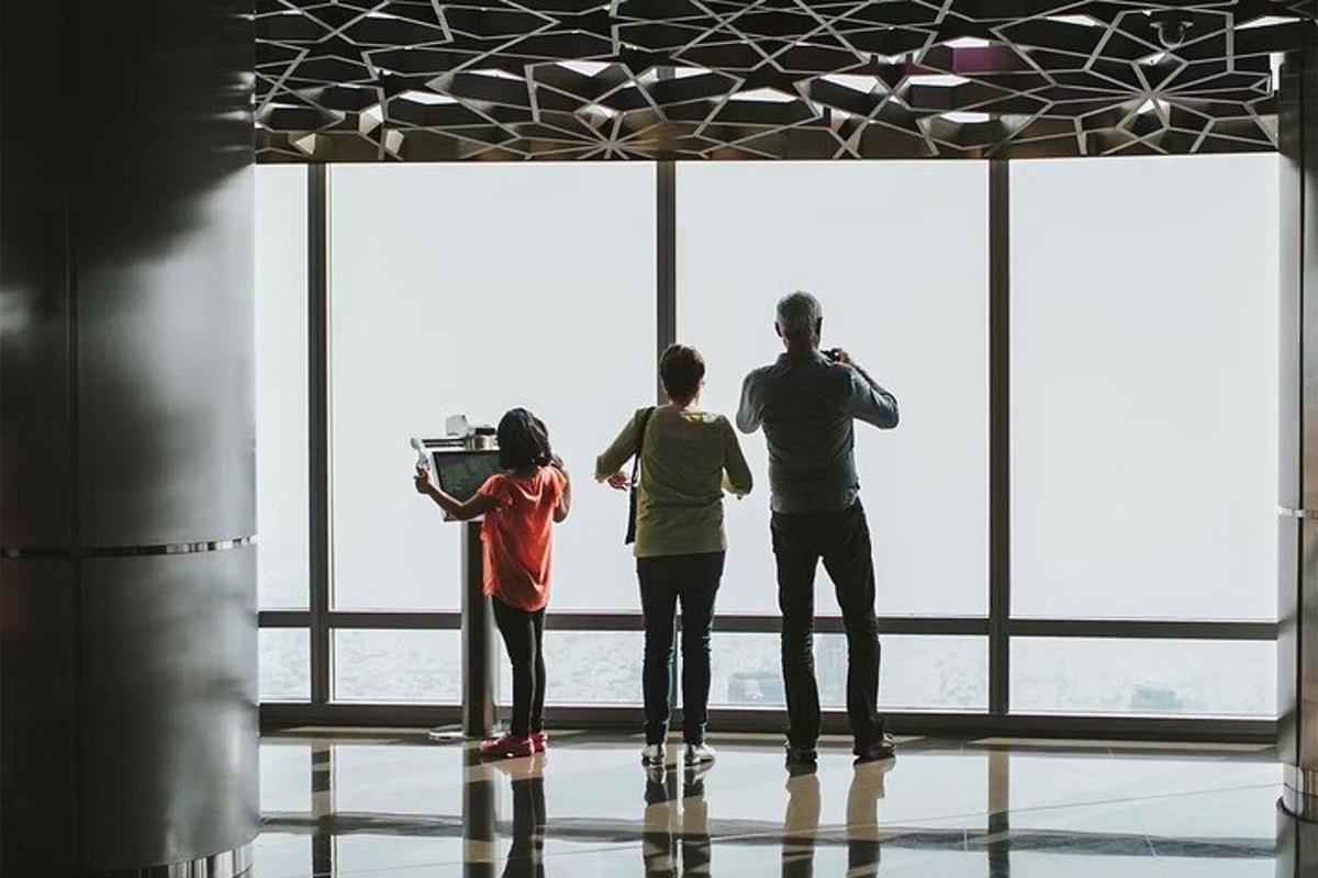 three people standing in front of a large window