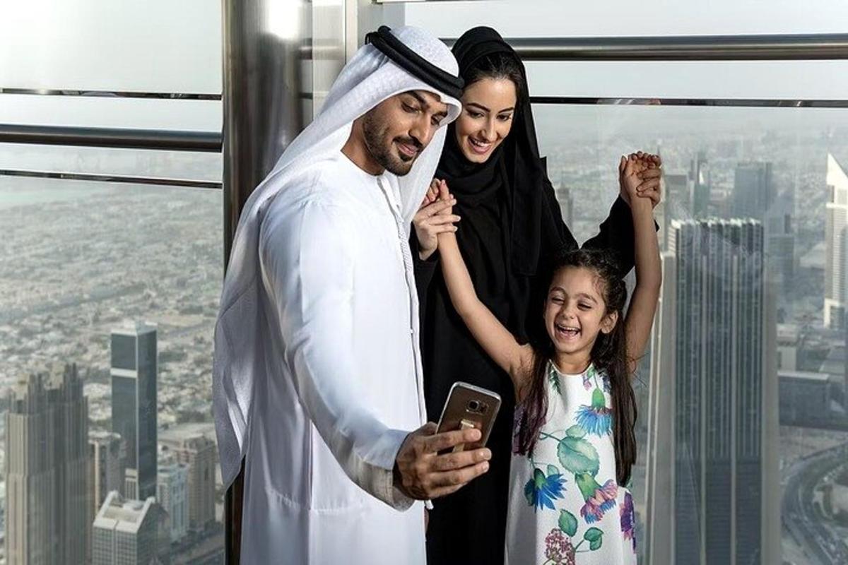 a man and a woman and a child looking at a cell phone