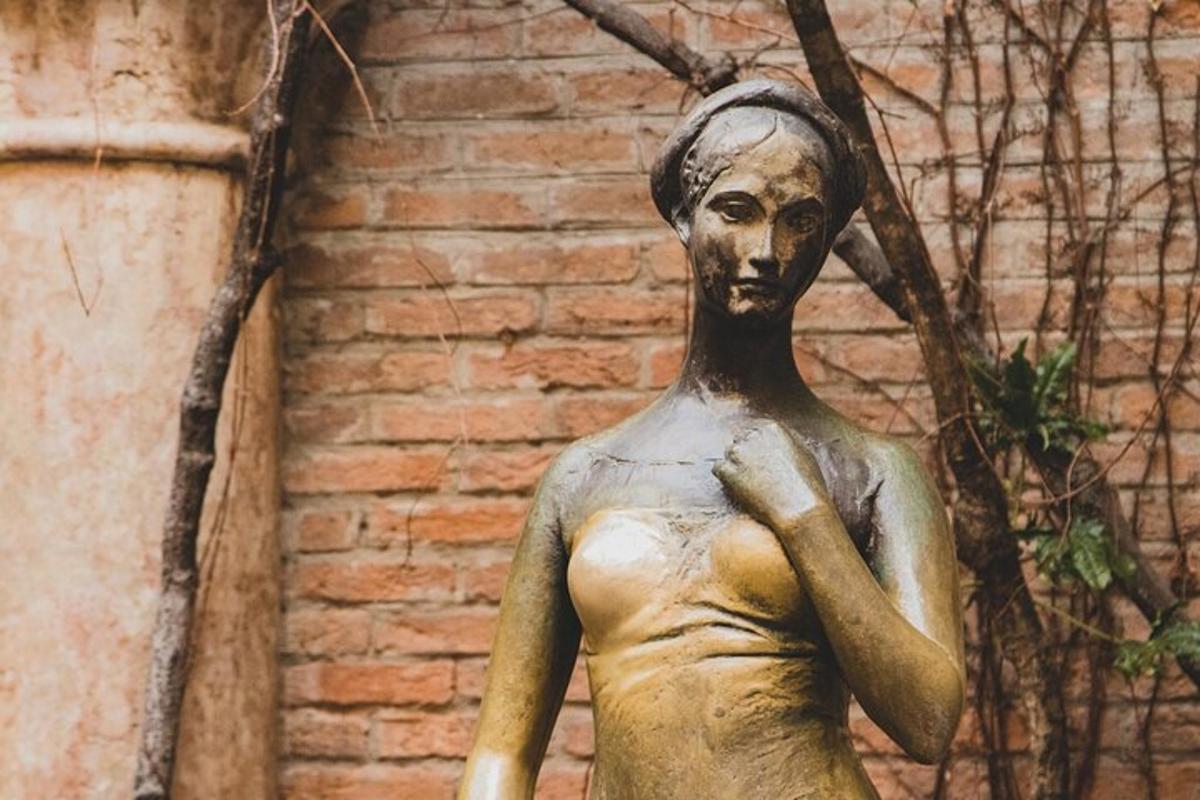 una estàtua d'una dona davant d'una paret de maons