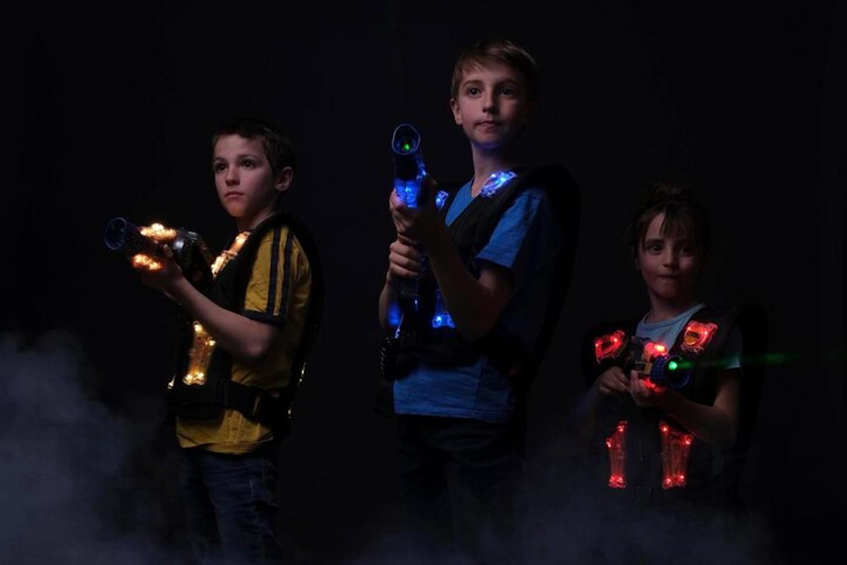 Tres niños pequeños sosteniendo luces en sus manos