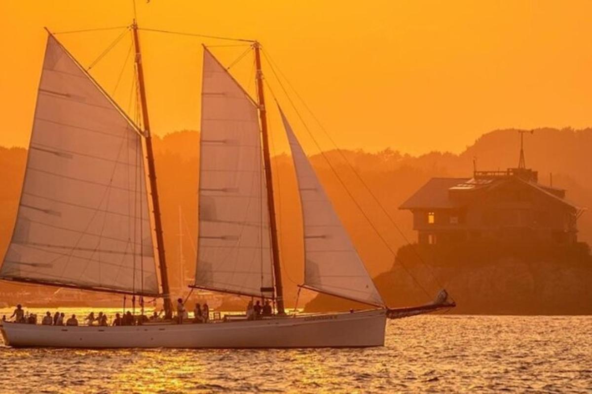 two sailboats in the water at sunset