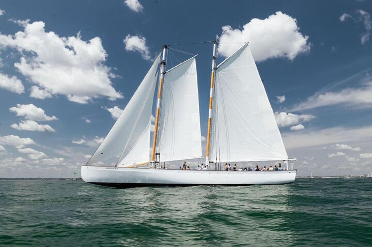 a boat with white sails in the water
