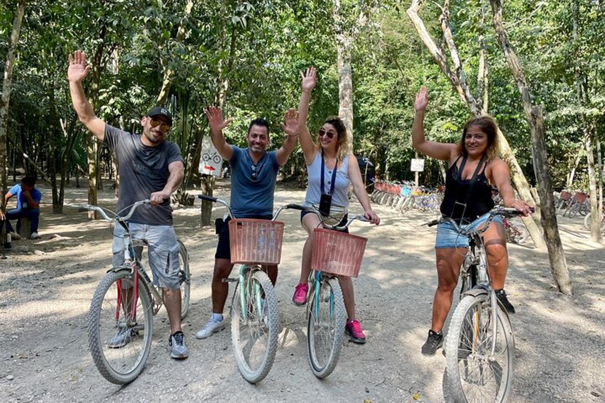 quattro persone in bicicletta con le mani in aria