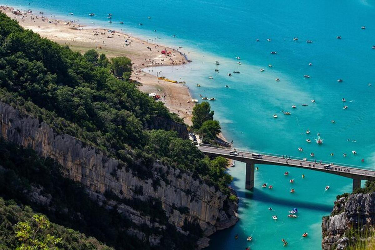 μια γέφυρα πάνω από μια παραλία με ανθρώπους στο νερό