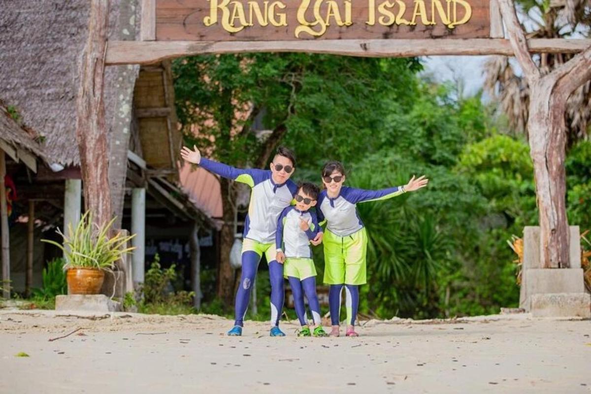 a family standing under a sign on the beach