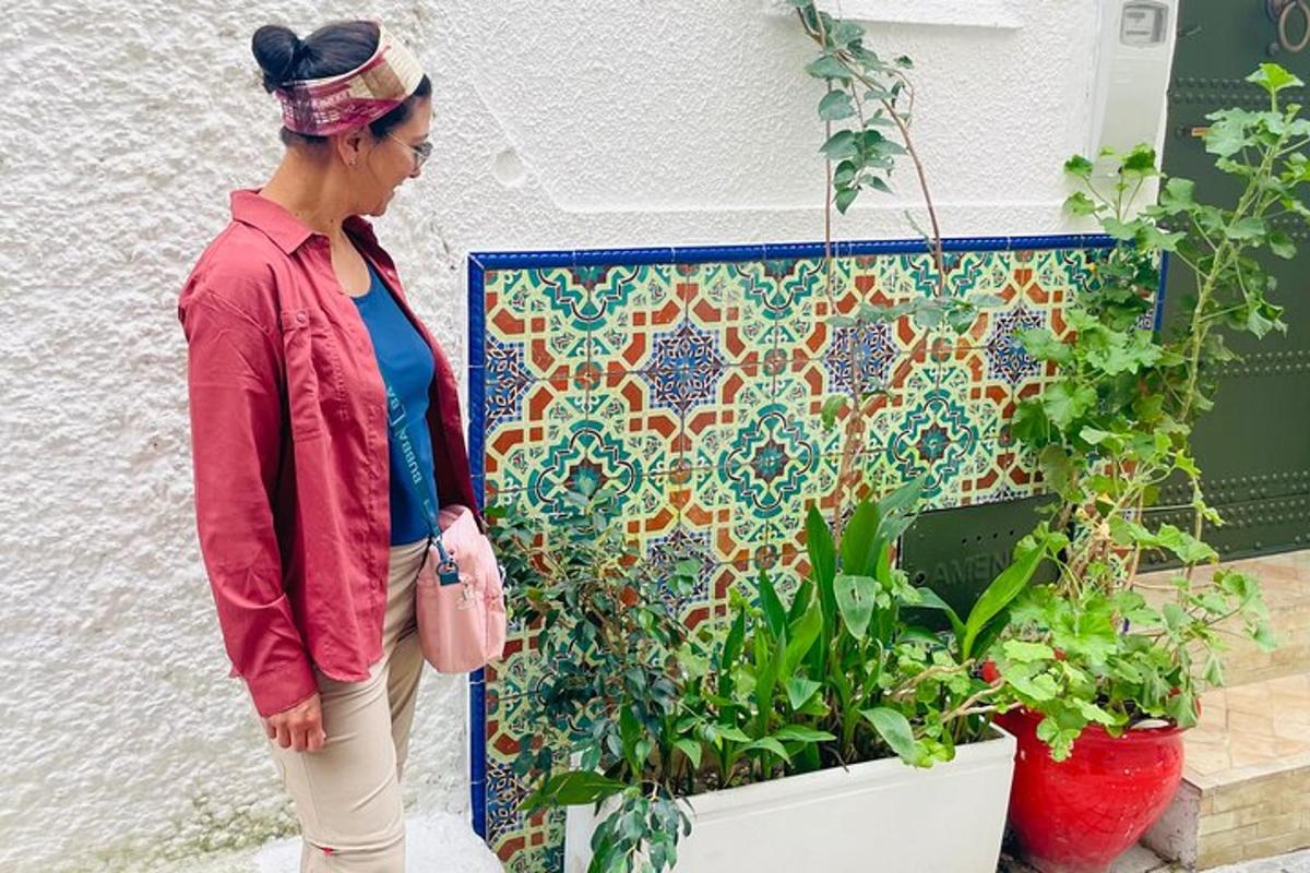 en kvinne som står foran en vegg med planter