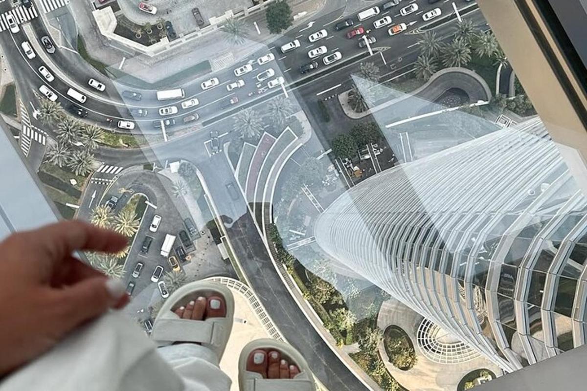 a person looking down from the glass floor of a building