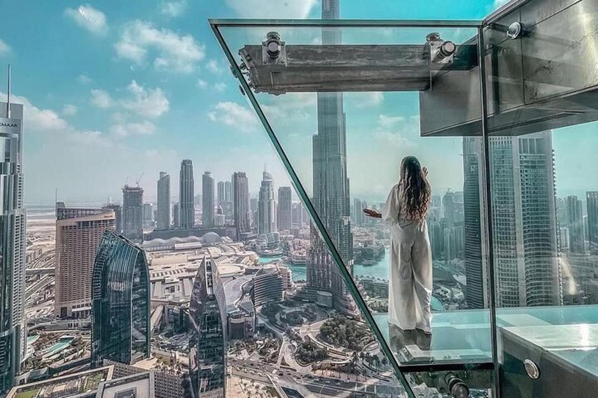 a woman standing on top of a skyscraper looking out at a city