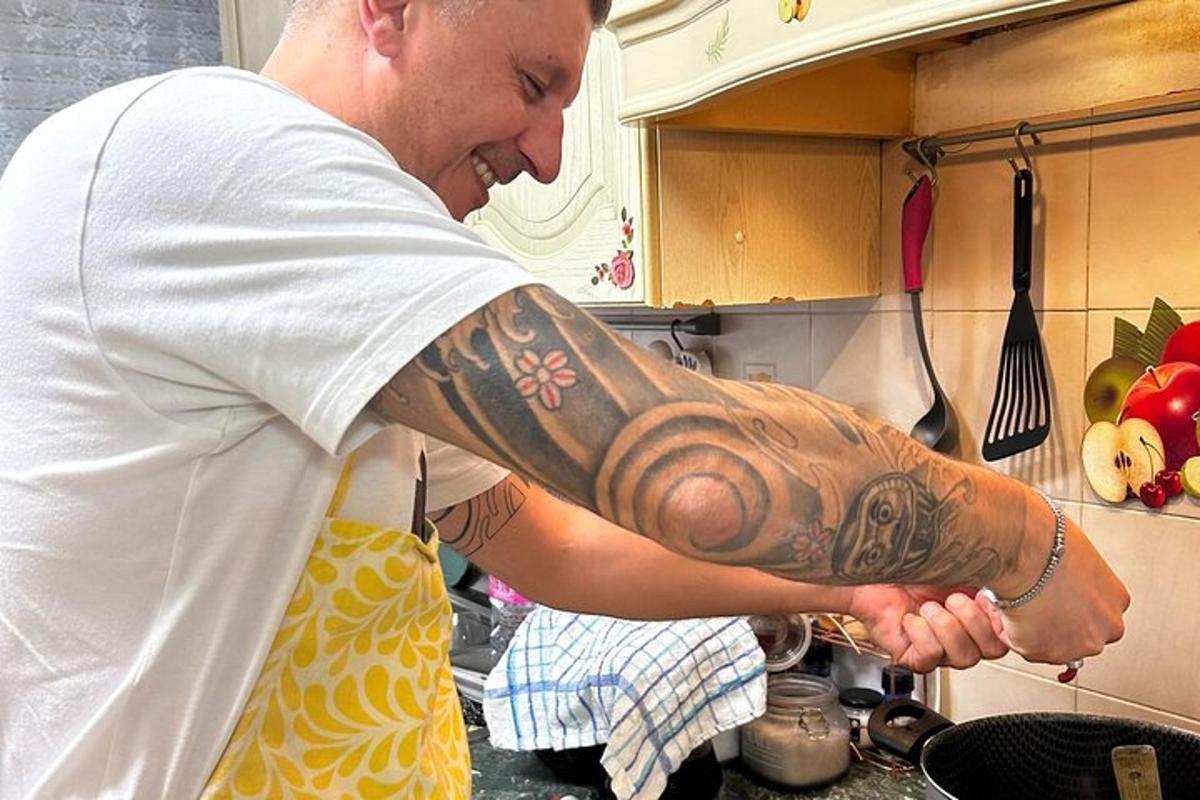 ein Mann mit einer Tätowierung auf dem Arm in einer Küche