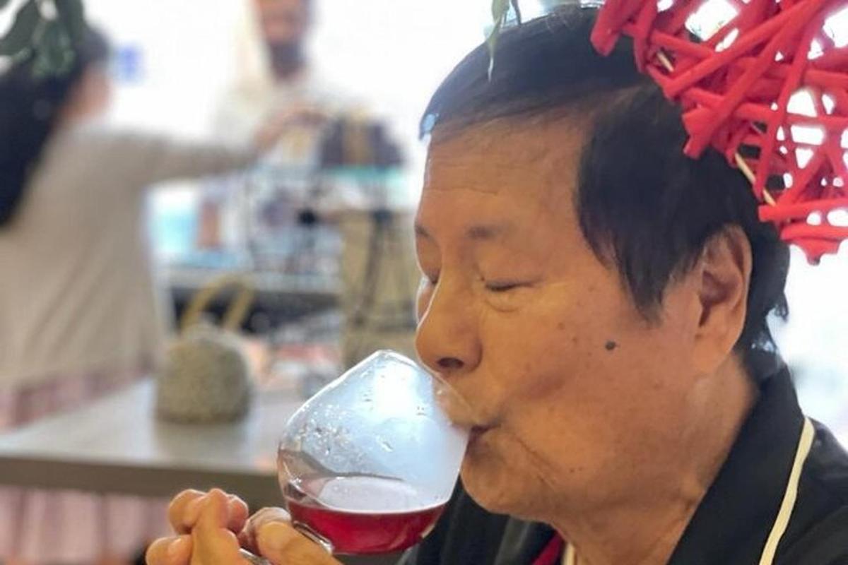 seorang wanita minum segelas wain merah