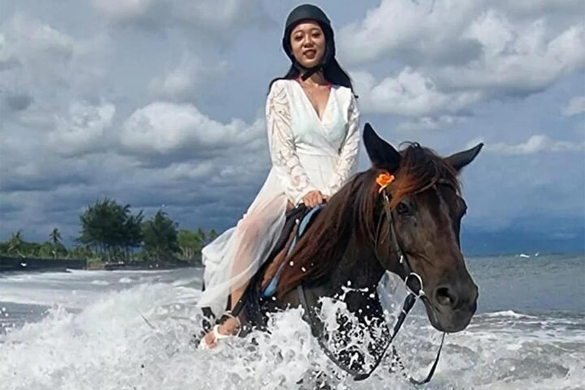 egy ruhás nő lovagol a tengerparton