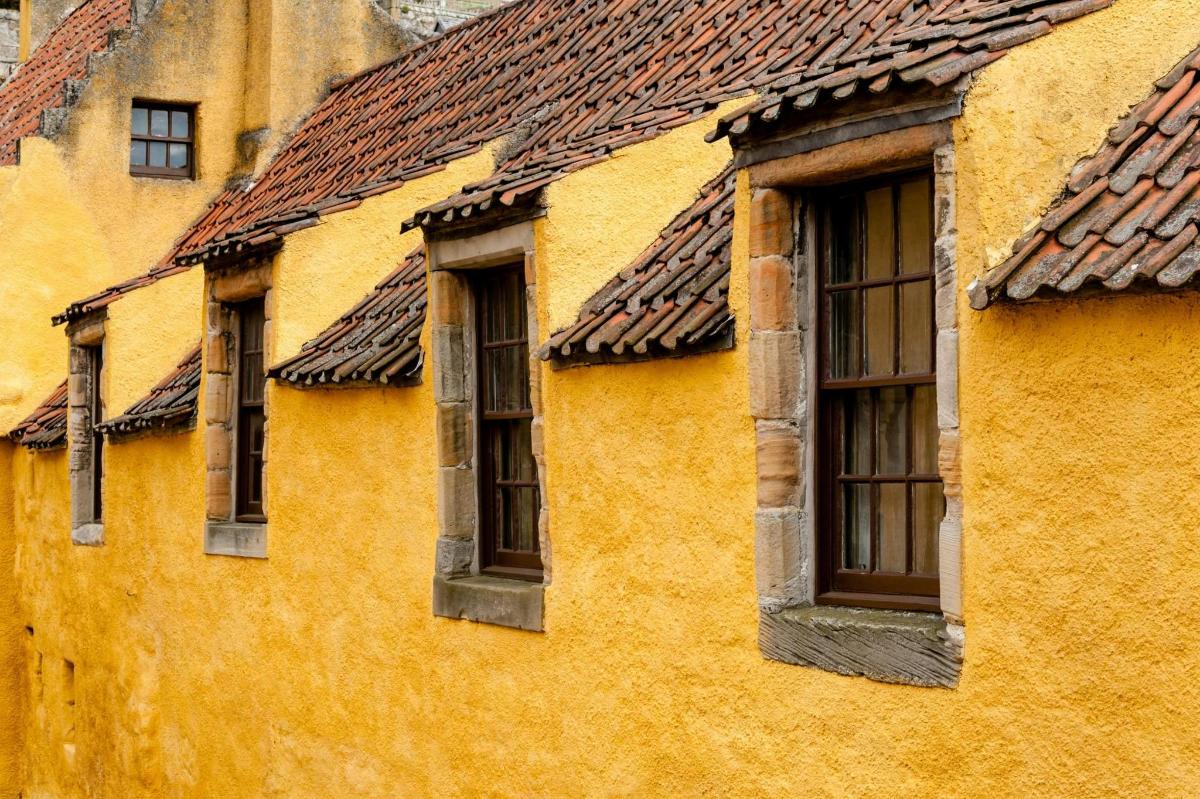 una fila di finestre su un edificio giallo
